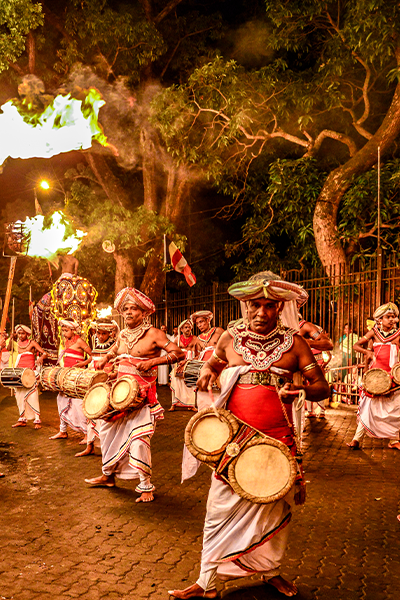 Traditional drummers performing in a Sri Lankan cultural procession at night
